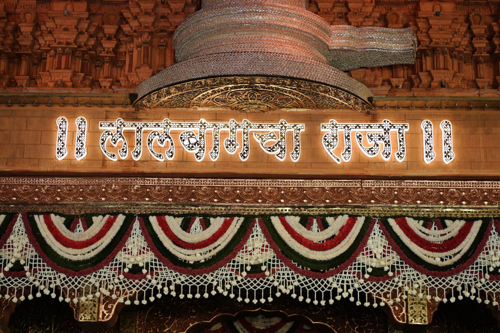 Lalbaugcha Raja lettering beneath the monumental Shivling