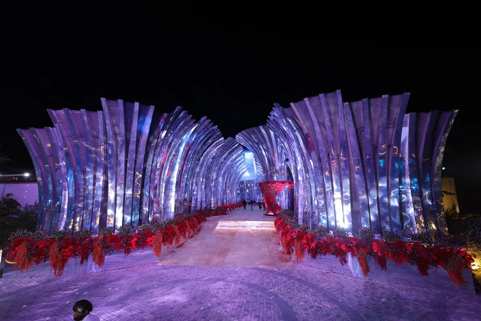 A mirrored sculptural arrival tunnel glowing at night