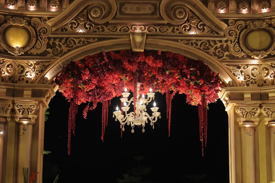 A richly layered floral arch framed in warm light