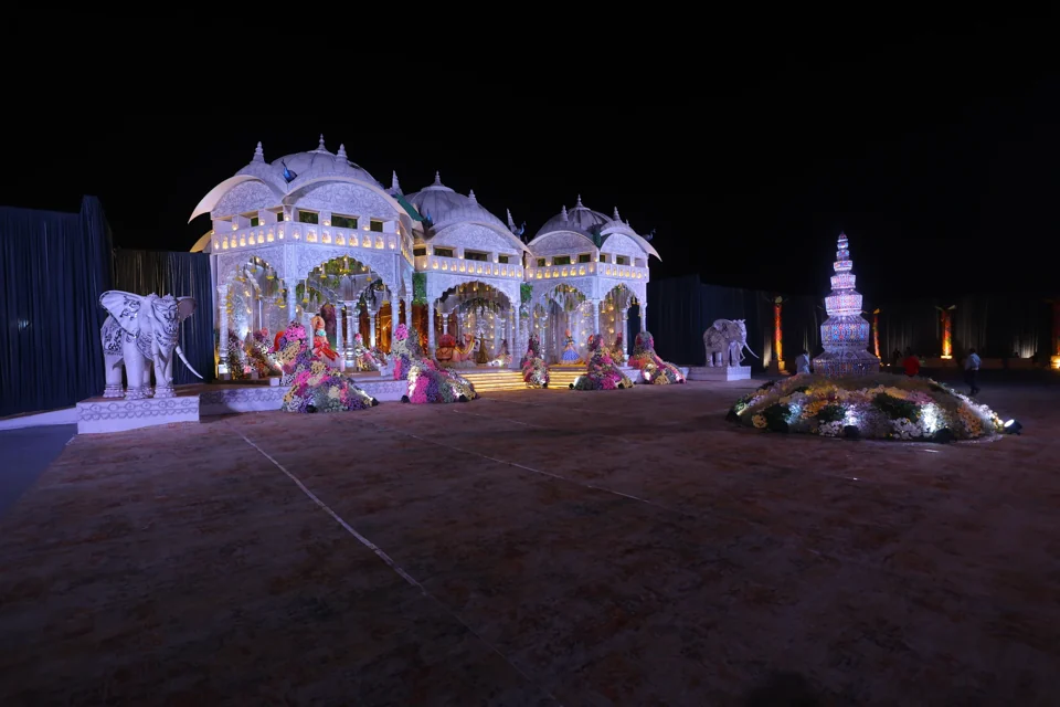 A white ceremonial pavilion surrounded by flowers