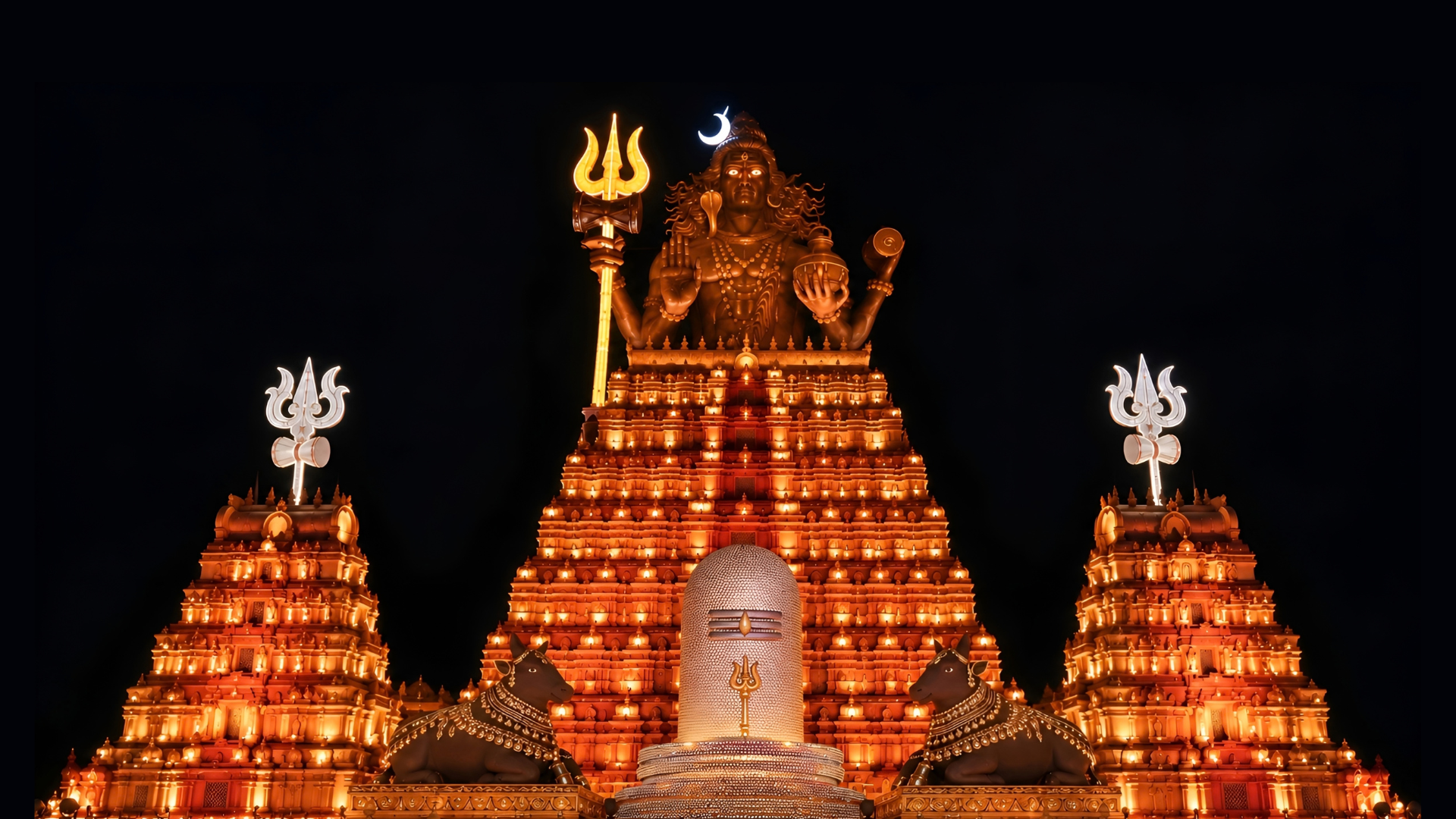 The illuminated Lalbaug Shiv Ji main gate with its central and flanking gopurams and trishuls
